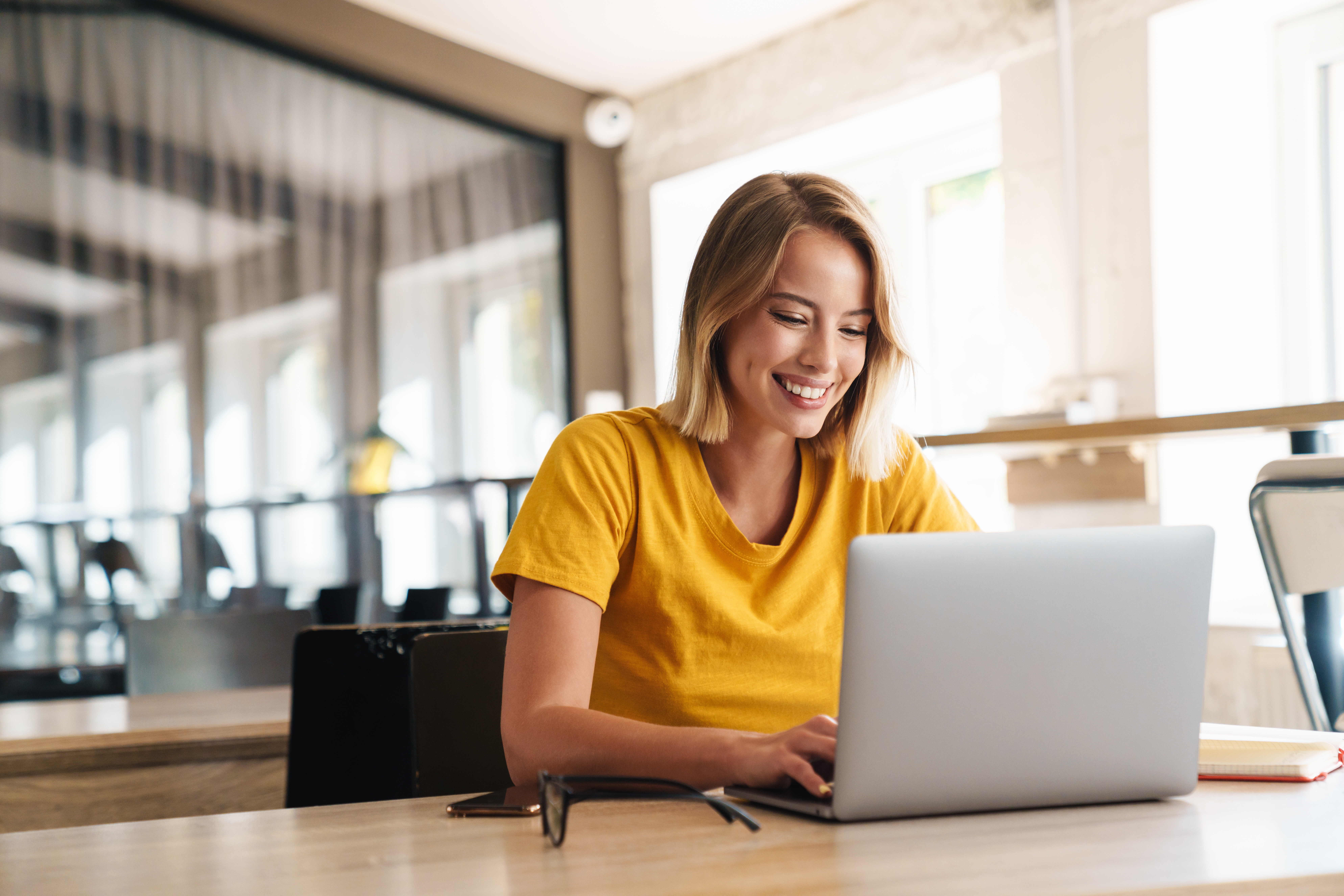 Young woman sitting at a computer smiling